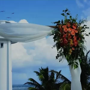 A photo of the famous Puerto Morelos leaning lighthouse and the gorgeous rooftop archway adorned with a gorgeous floral arrangement. The perfect location for your dream wedding.
