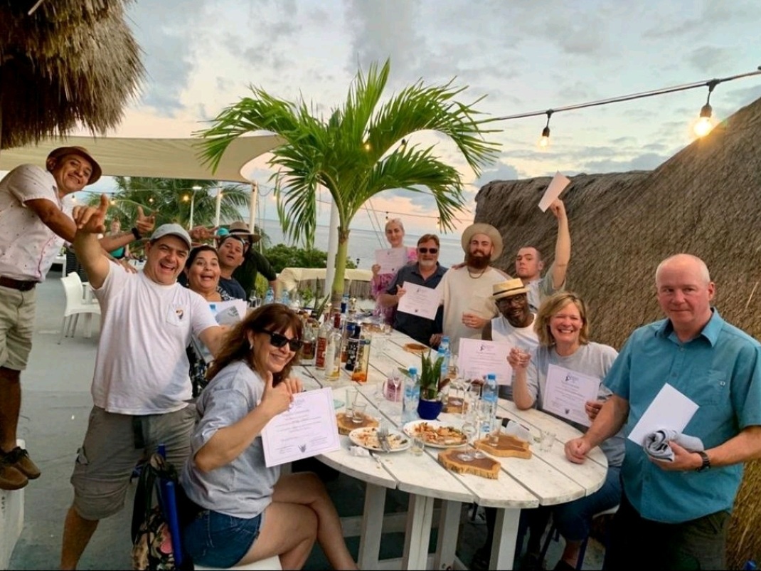 A group on La Sirena Puerto Morelos rooftop, each one holding certificates of completion of Tequila University.