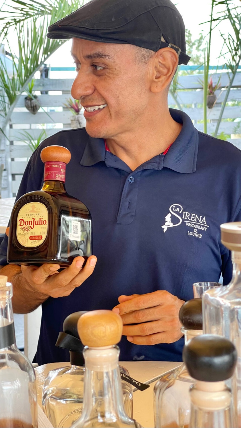 El Maestro Tequilero holding a bottle of Don Julio tequila during Tequila University on Mondays at 4pm at La Sirena Puerto Morelos.