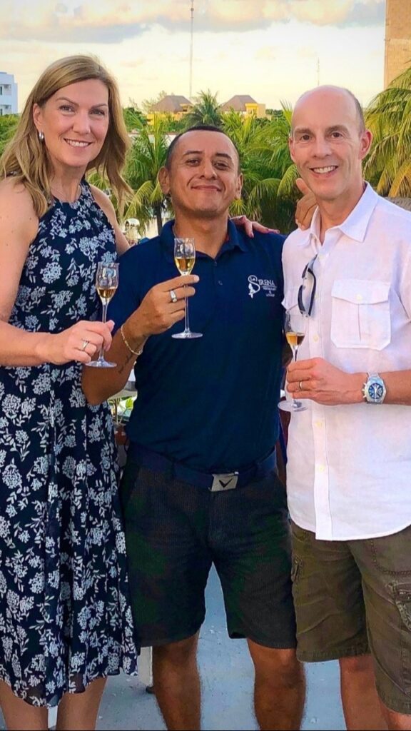 A man and woman attending La Sirena's Tequila University pose with the Maestro Tequilero. Each one is holding a glass of tequila.